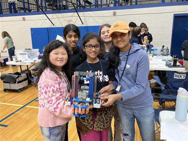 Students pose for a photo with their robot.